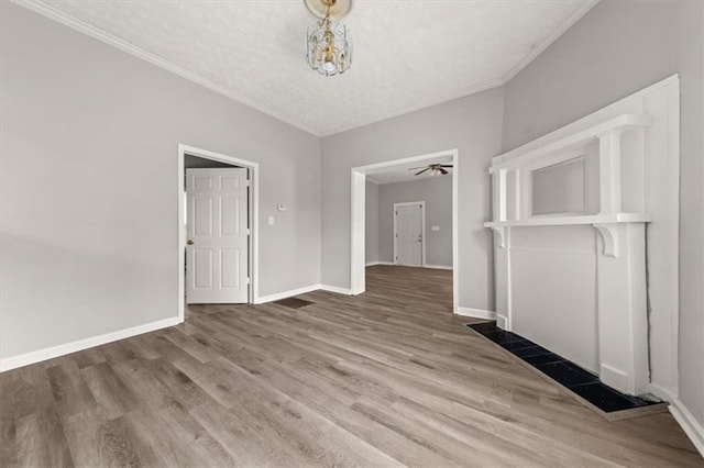 unfurnished dining area featuring a textured ceiling, light hardwood / wood-style floors, and crown molding