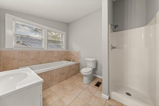 full bathroom featuring vanity, separate shower and tub, toilet, a textured ceiling, and tile patterned flooring