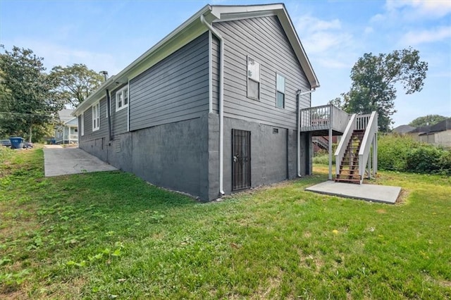 rear view of house with a wooden deck and a yard