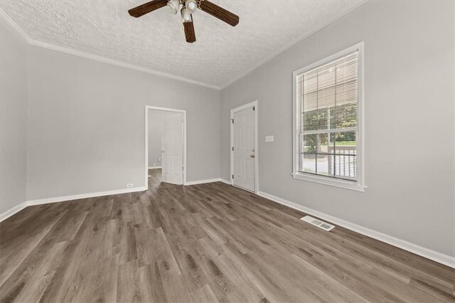 empty room with ceiling fan, a textured ceiling, ornamental molding, and hardwood / wood-style flooring