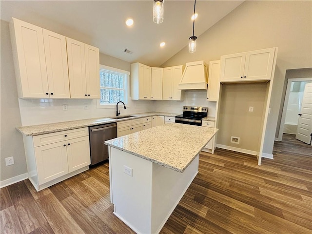 kitchen featuring premium range hood, a sink, a kitchen island, appliances with stainless steel finishes, and white cabinets