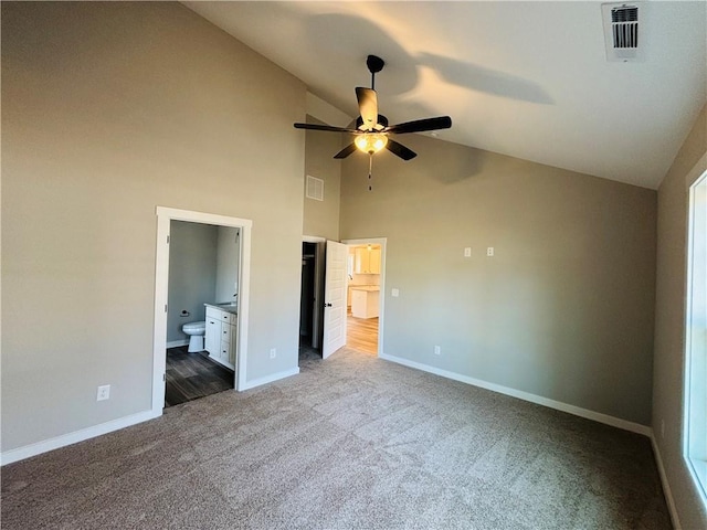 unfurnished bedroom featuring dark colored carpet, visible vents, baseboards, and ensuite bath