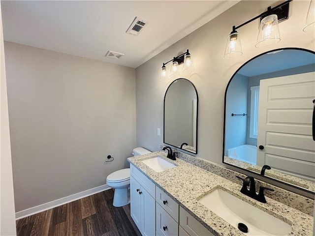 bathroom with visible vents, wood finished floors, and a sink