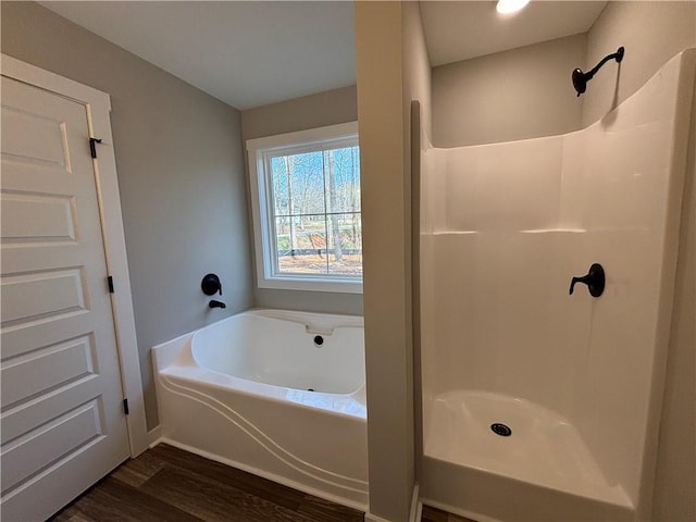 full bath featuring a bath, a shower, and wood finished floors