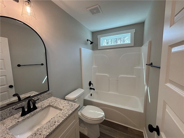 full bathroom with visible vents, toilet, shower / bath combination, wood finished floors, and vanity