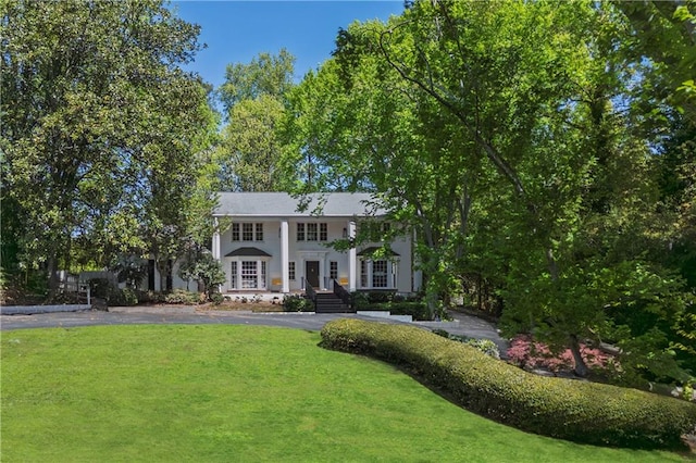 greek revival inspired property featuring aphalt driveway and a front yard