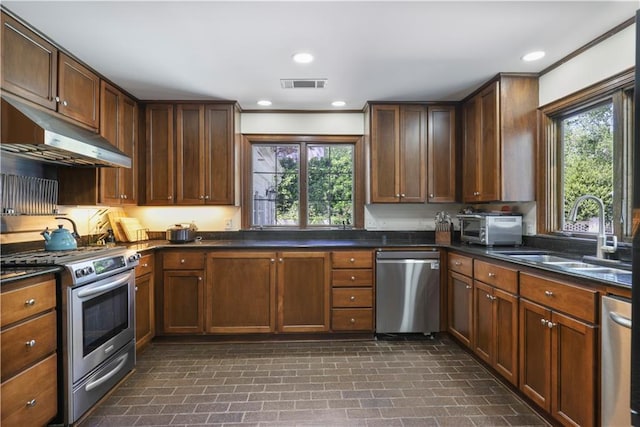 kitchen featuring a wealth of natural light, under cabinet range hood, stainless steel appliances, and a sink
