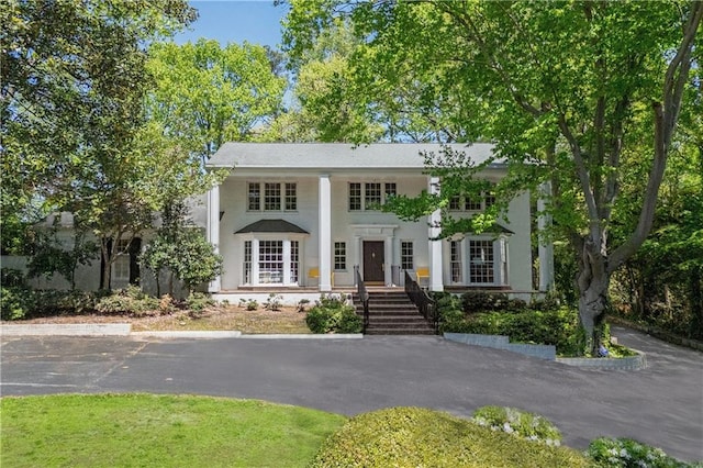 greek revival house with uncovered parking and stucco siding