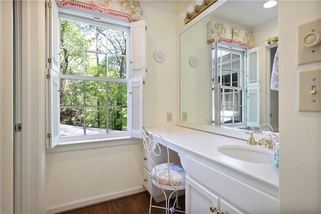 bathroom with wood finished floors, baseboards, and vanity