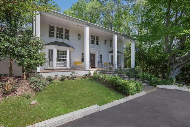 neoclassical home featuring a front yard