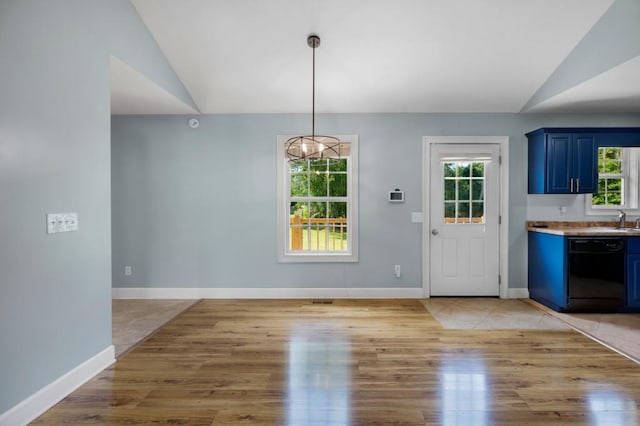 unfurnished dining area featuring light wood-style floors and vaulted ceiling