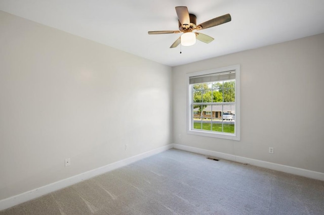 empty room featuring a ceiling fan, carpet, and baseboards