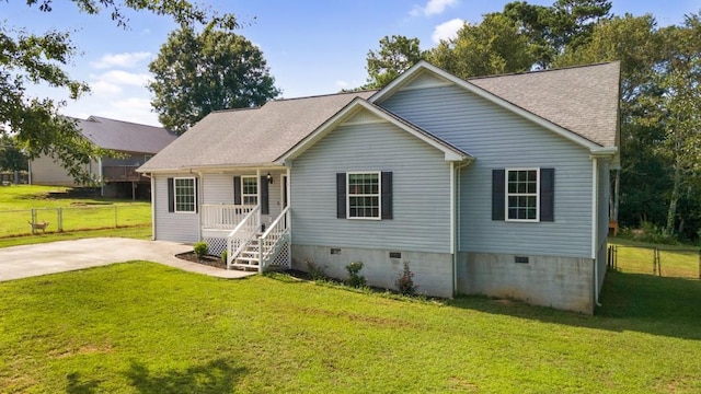 view of front of house with a front yard, crawl space, roof with shingles, and fence