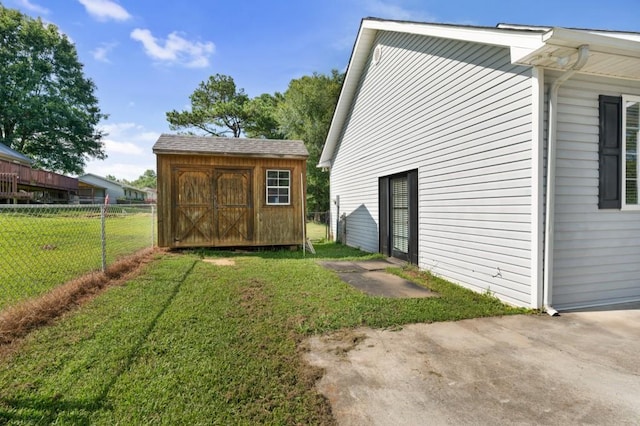 exterior space featuring a shed, a lawn, an outdoor structure, and fence