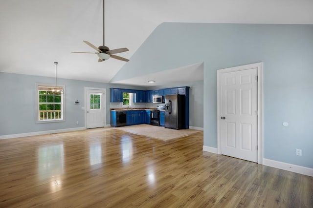 unfurnished living room with baseboards, high vaulted ceiling, ceiling fan with notable chandelier, and light wood-style floors