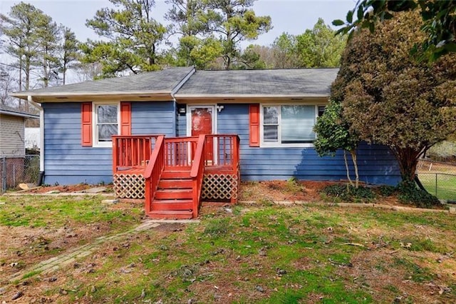 ranch-style home with a front yard and fence