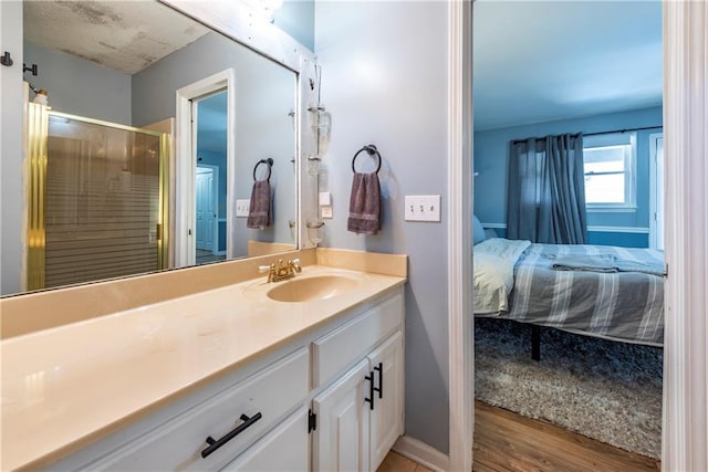 bathroom featuring hardwood / wood-style flooring, vanity, and an enclosed shower