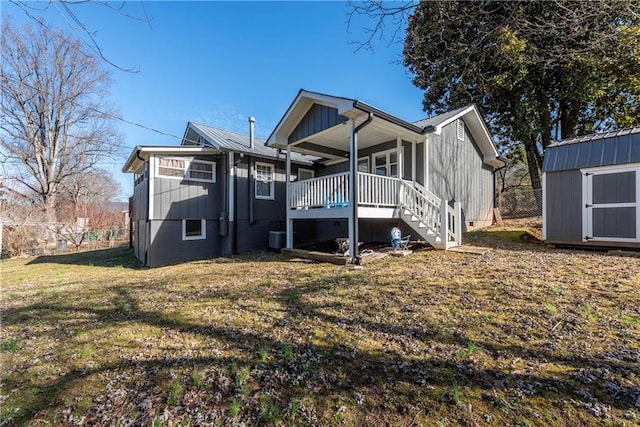 back of house featuring a storage shed, a yard, and a deck