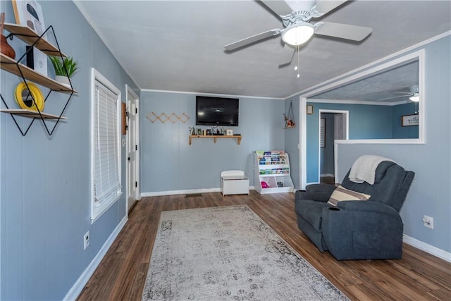 sitting room with ornamental molding, dark wood-type flooring, and ceiling fan