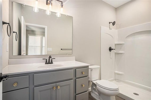 bathroom featuring vanity, toilet, and walk in shower