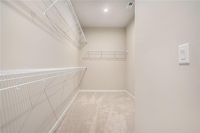 spacious closet featuring light carpet