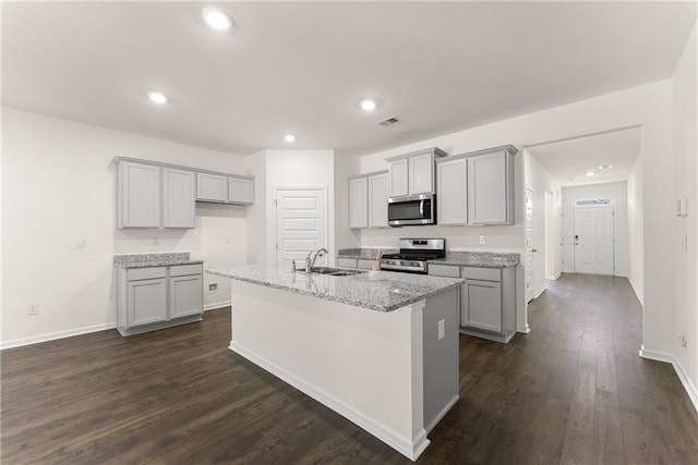 1278 Daurian Dr, Statham, GA 30666 - kitchen featuring appliances with stainless steel finishes, gray cabinetry, a kitchen island with sink, dark wood finished floors, and recessed lighting