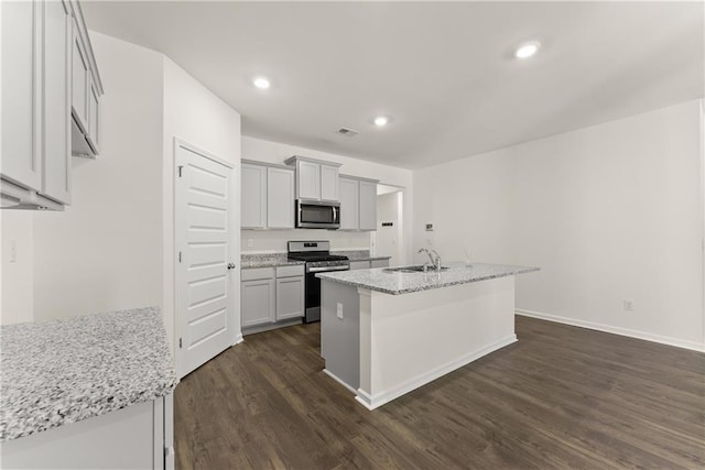 1278 Daurian Dr, Statham, GA 30666 - kitchen with stainless steel appliances, dark wood-style flooring, a center island with sink, light stone counters, and recessed lighting