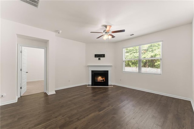 1278 Daurian Dr, Statham, GA 30666 - unfurnished living room with ceiling fan, a warm lit fireplace, and dark wood finished floors