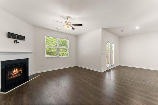 1278 Daurian Dr, Statham, GA 30666 - unfurnished living room featuring plenty of natural light, dark wood finished floors, a lit fireplace, and ceiling fan