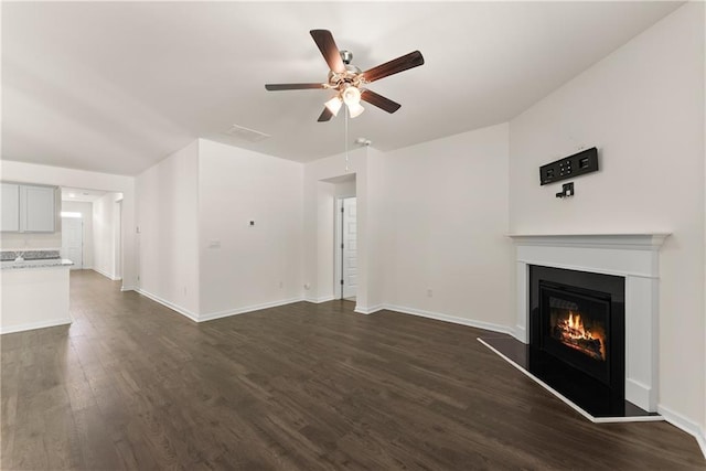 1278 Daurian Dr, Statham, GA 30666 - unfurnished living room featuring ceiling fan, a warm lit fireplace, and dark wood-style flooring