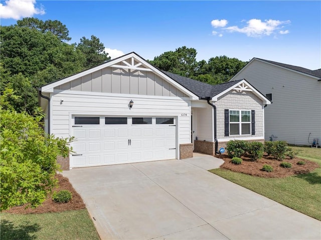 1278 Daurian Dr, Statham, GA 30666 - view of front of home with concrete driveway, an attached garage, brick siding, board and batten siding, and a shingled roof