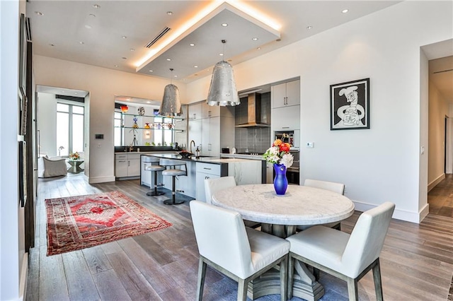 dining area with baseboards, visible vents, wood finished floors, and recessed lighting