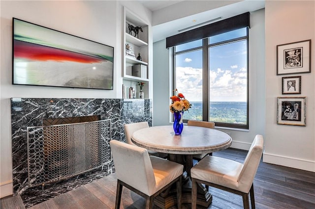 dining room with built in features, baseboards, and wood finished floors