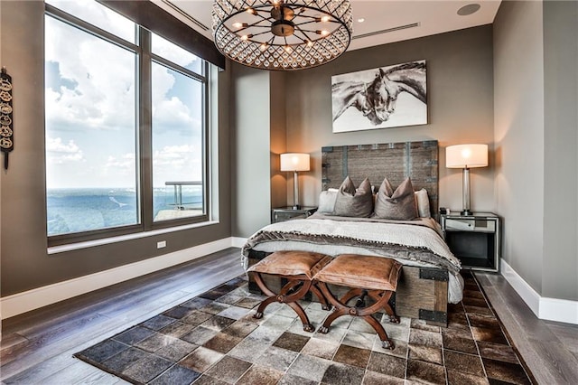 bedroom with a notable chandelier, wood finished floors, and baseboards