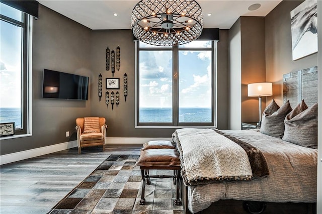 bedroom featuring multiple windows, baseboards, and wood finished floors