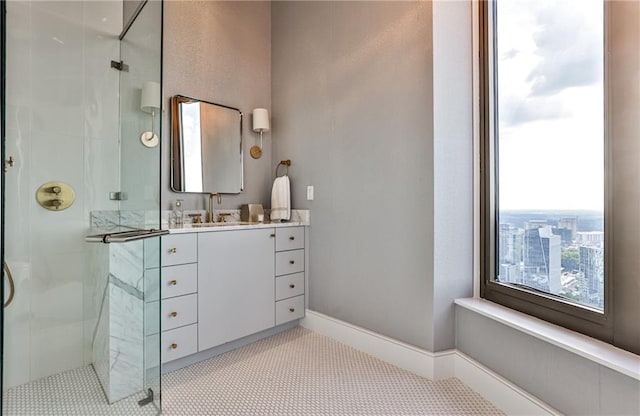 bathroom featuring a stall shower, vanity, and baseboards