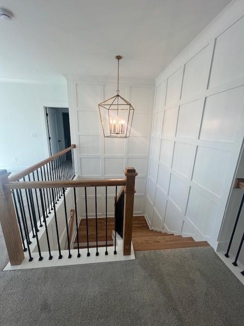 staircase featuring carpet floors and a chandelier