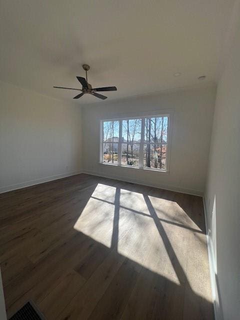 spare room featuring ceiling fan and dark wood-type flooring