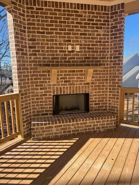 wooden deck with a brick fireplace