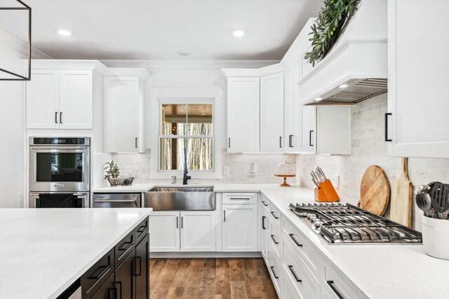 kitchen featuring backsplash, stainless steel appliances, sink, and white cabinets