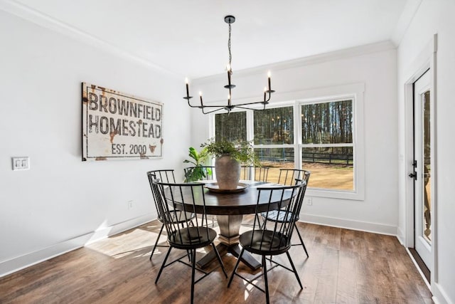 dining area featuring crown molding, an inviting chandelier, and hardwood / wood-style floors