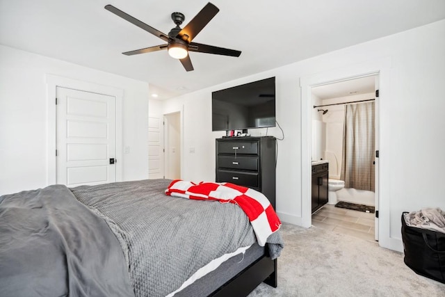 bedroom featuring ceiling fan, connected bathroom, and light carpet