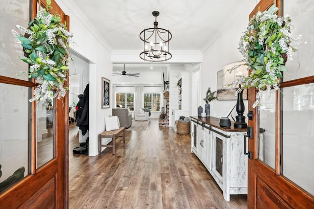 hall featuring crown molding, an inviting chandelier, and dark wood-type flooring