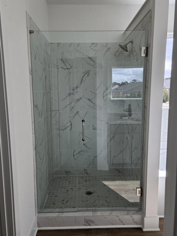 full bathroom featuring a shower stall and baseboards