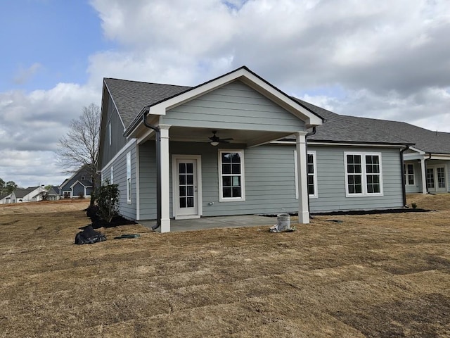 view of front of home featuring a patio area, ceiling fan, and roof with shingles