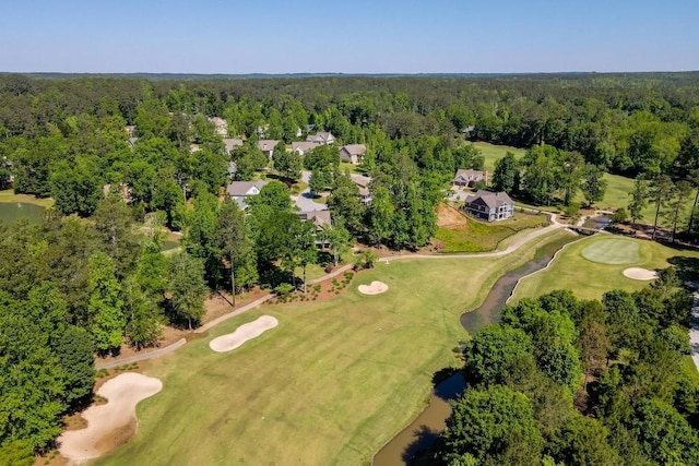 birds eye view of property with view of golf course and a forest view