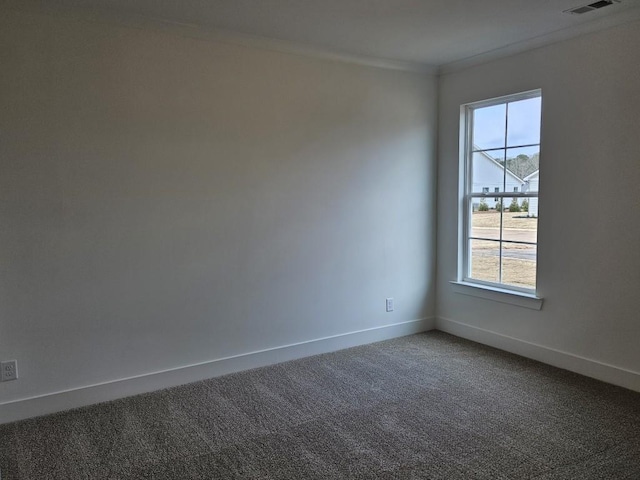 carpeted empty room with ornamental molding, visible vents, and baseboards