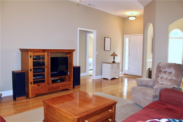 265 Mona Ct, Winder, GA 30680 - living room with light wood finished floors, arched walkways, and baseboards