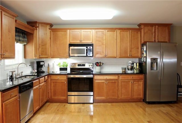 265 Mona Ct, Winder, GA 30680 - kitchen with stainless steel appliances, a sink, light wood-style flooring, and decorative backsplash