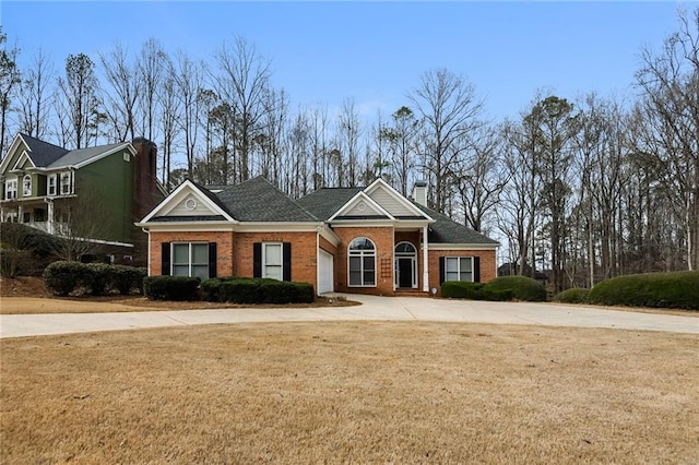 view of front facade featuring brick siding, a chimney, and a front yard